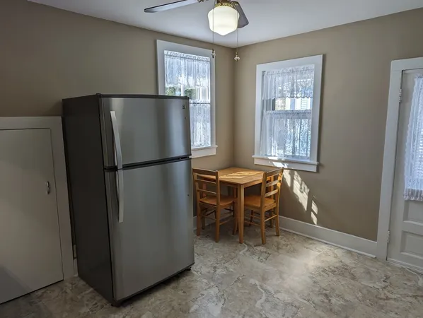 an empty room with wooden floor fireplace and windows