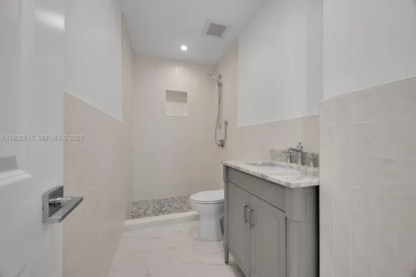 a bathroom with a granite countertop sink a toilet and a mirror