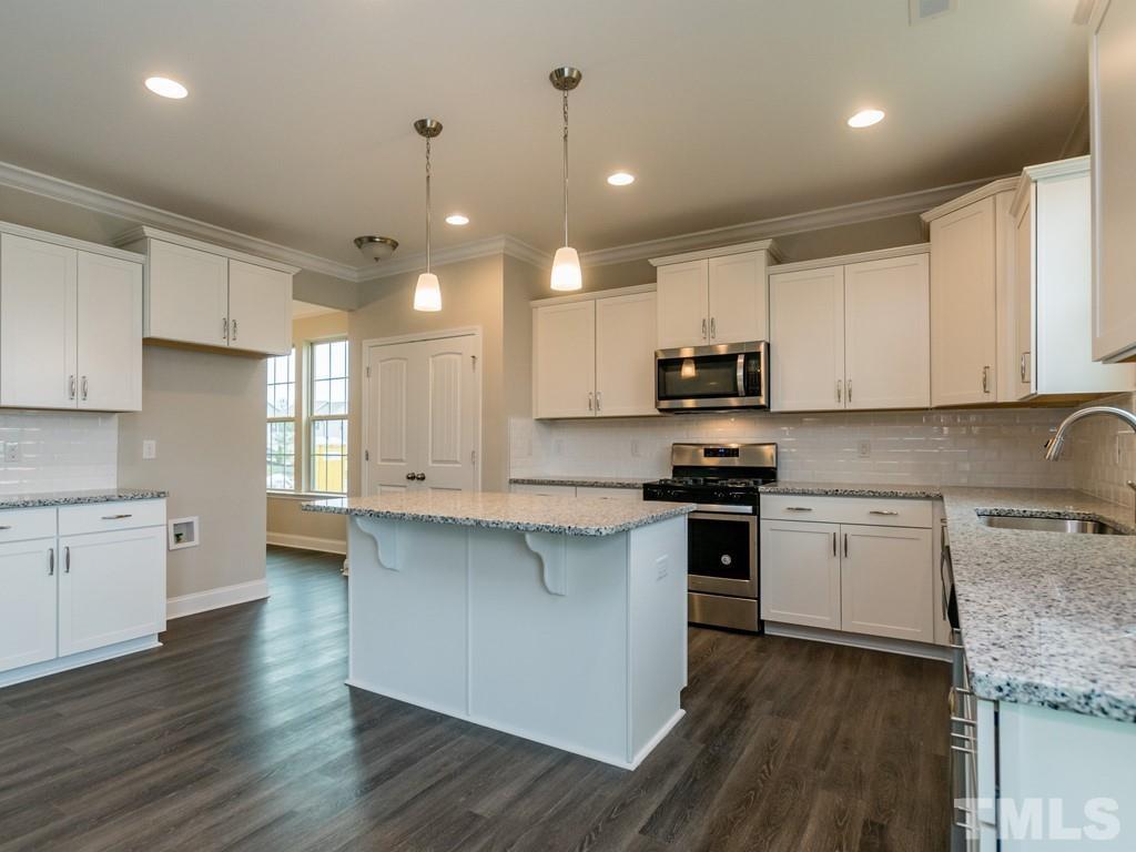 131 Weldon Lane Angier, NC 27501 - Photo 8 of 24 a kitchen with stainless steel appliances granite countertop wooden cabinets a stove a sink and a microwave