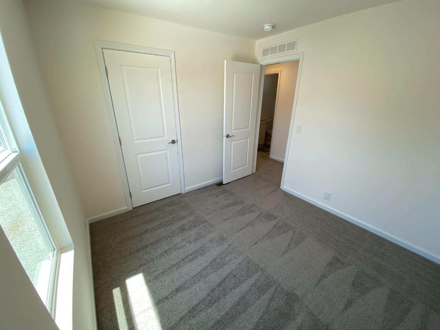 128 Pera Drive, Unit 128 Watsonville, CA 95076 - Photo 21 of 29 an empty room with wooden floor and windows