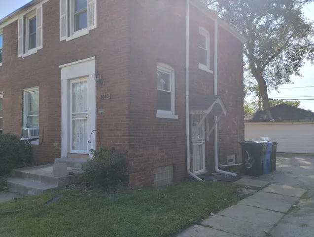 a view of a brick house with a yard and fountain