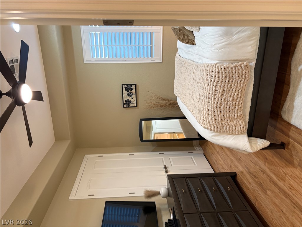 977 Rhyolite Terrace Henderson, NV 89011 - Photo 24 of 33 Rich wood flooring anchors this inviting bedroom, complete with a recessed ceiling and plantation shutters.
