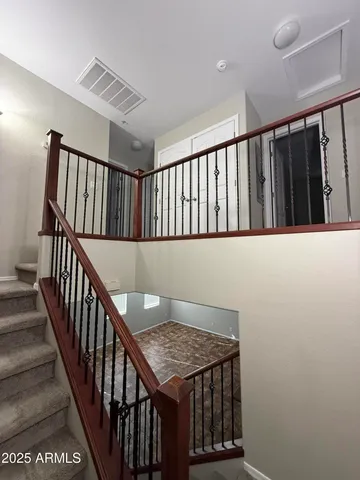 a view of staircase with railing and white walls
