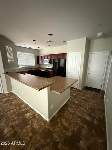 a large kitchen with cabinets appliances and a counter space