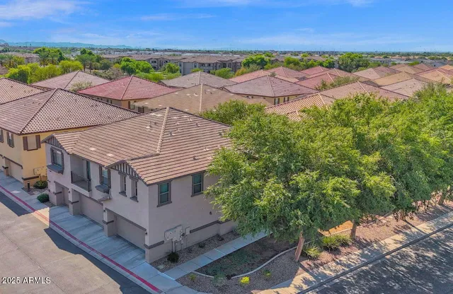 an aerial view of residential houses with outdoor space and trees