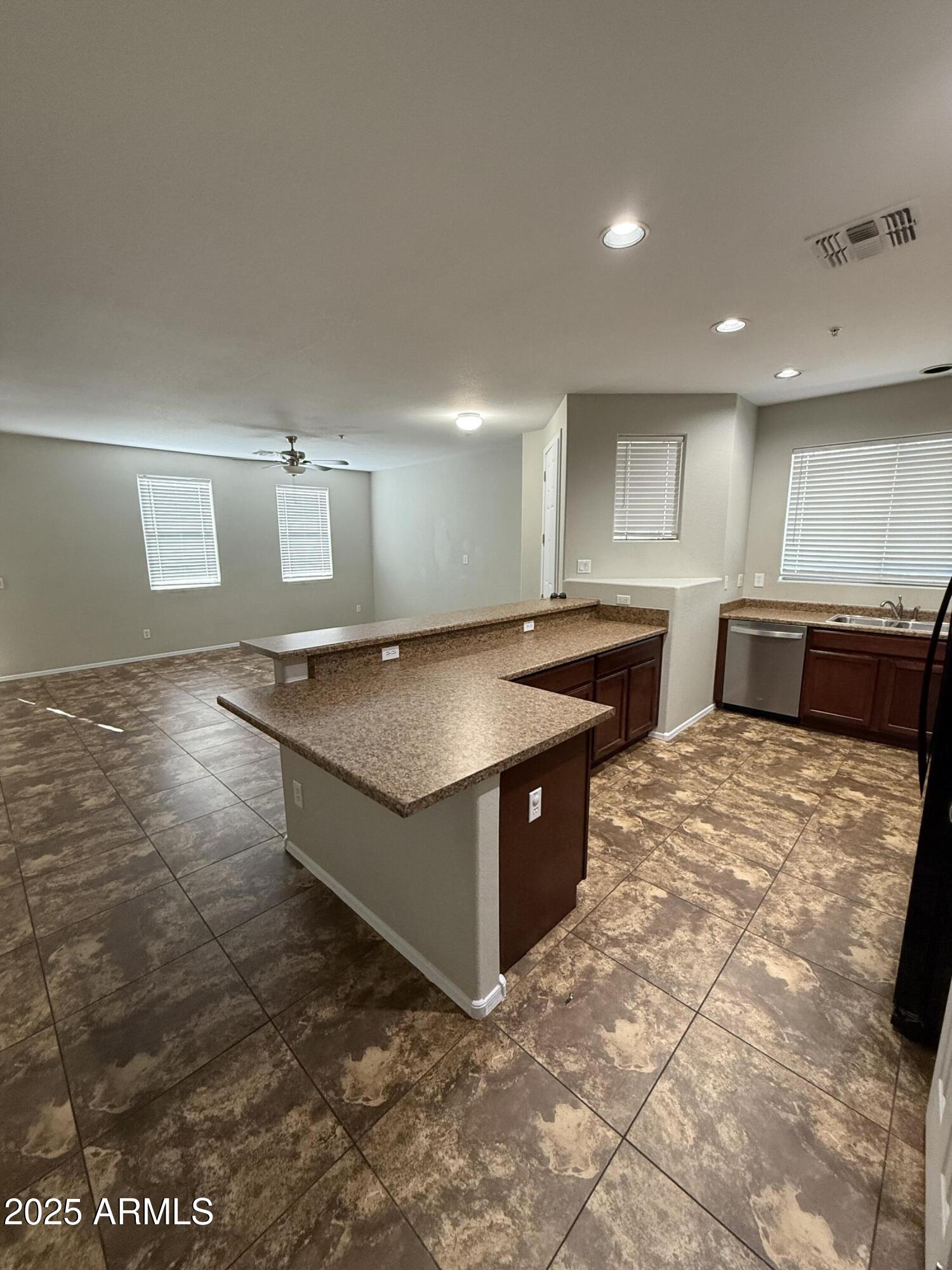 1265 South Aaron, Unit 351 Mesa, AZ 85209 - Photo 7 of 17 a large kitchen with kitchen island granite countertop a sink and white cabinets