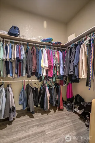 a view of walk in closet with clothes and shoes