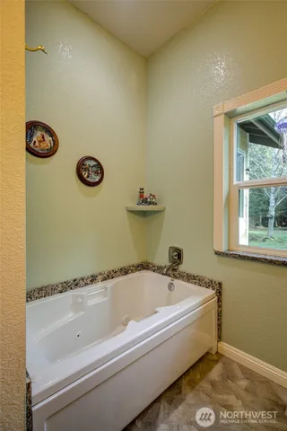 a bathroom with a tub and a window