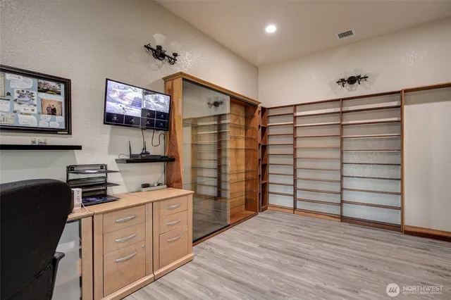 a kitchen with stainless steel appliances cabinets and a wooden floor
