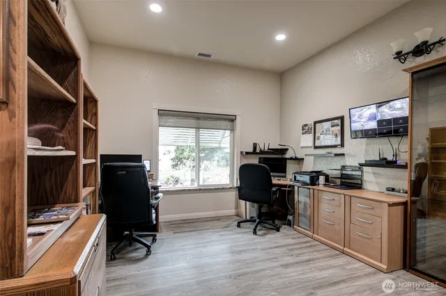 a view of a workspace with furniture and a window