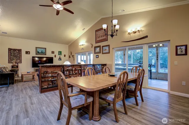 a view of a dining room with furniture a chandelier and wooden floor