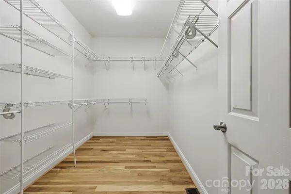 an empty room with windows and ceiling fan