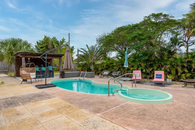a view of a house with backyard and sitting area