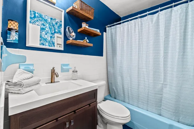 a bathroom with a sink a toilet and shower curtain