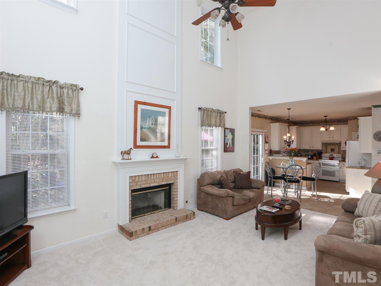 4604 Drewbridge Way Raleigh, NC 27604 - Photo 12 of 24 a living room with furniture a fireplace and a flat screen tv