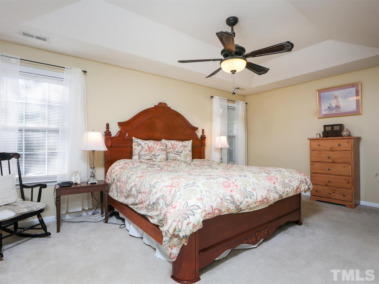 4604 Drewbridge Way Raleigh, NC 27604 - Photo 14 of 24 a bedroom with a bed a dresser and a chandelier
