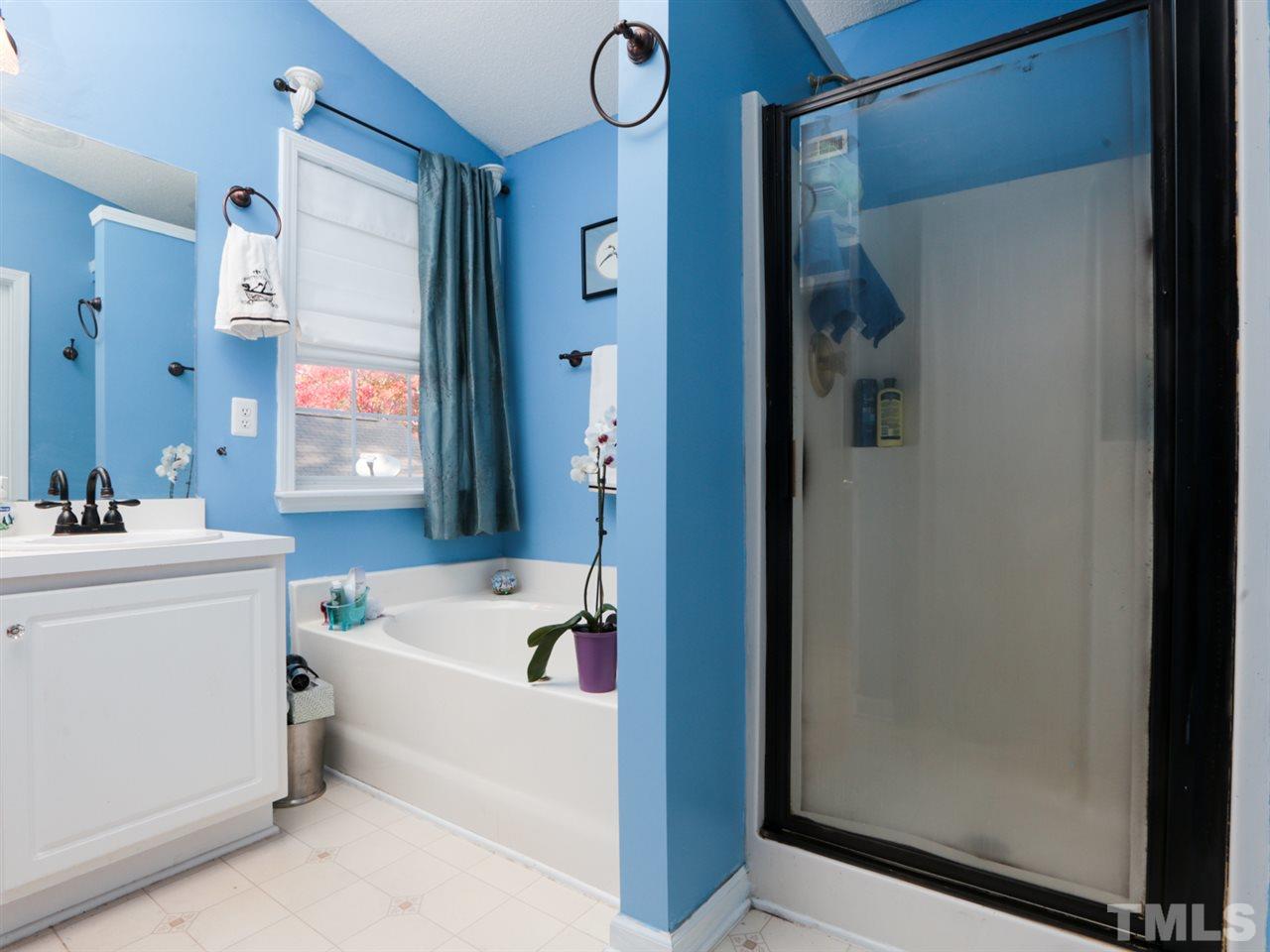 4604 Drewbridge Way Raleigh, NC 27604 - Photo 16 of 24 a white bath tub sitting next to a white sink and vanity