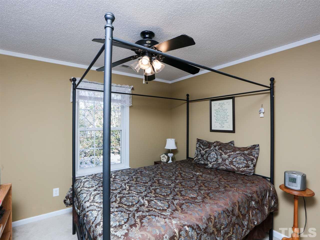 4604 Drewbridge Way Raleigh, NC 27604 - Photo 18 of 24 a bedroom with a bed and a chandelier