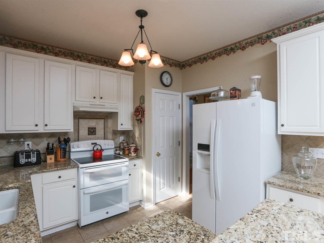 4604 Drewbridge Way Raleigh, NC 27604 - Photo 6 of 24 a kitchen with white cabinets and refrigerator