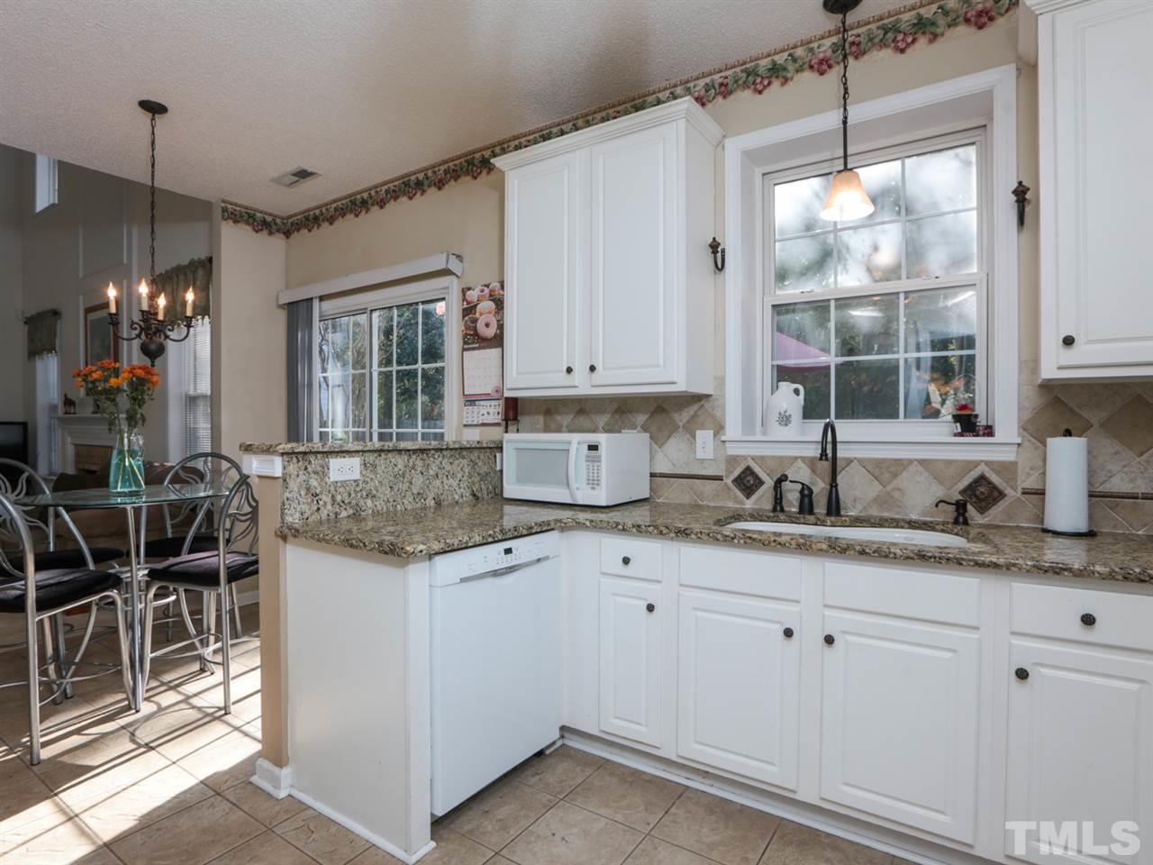 4604 Drewbridge Way Raleigh, NC 27604 - Photo 7 of 24 a kitchen with a sink window and cabinets