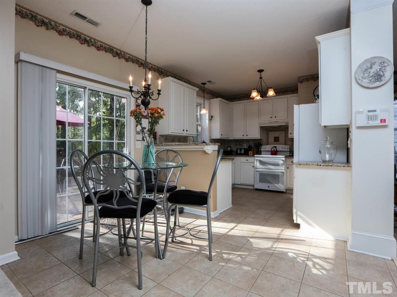 4604 Drewbridge Way Raleigh, NC 27604 - Photo 8 of 24 a kitchen with a table chairs and a view of kitchen