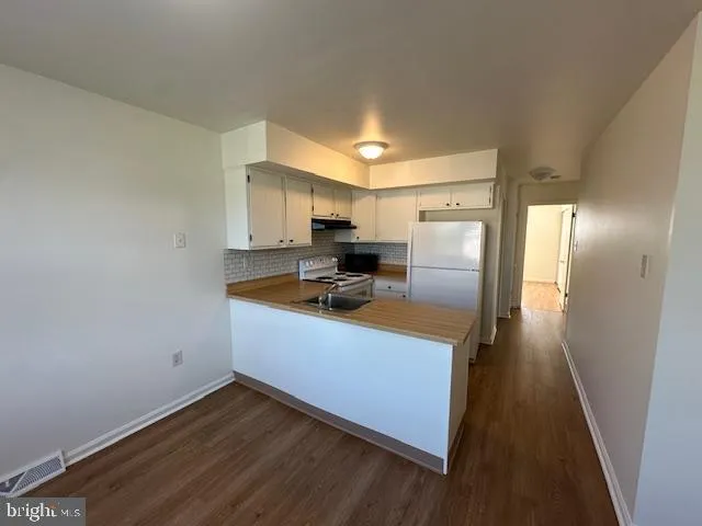 a kitchen with a refrigerator sink and cabinets