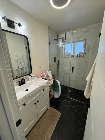 a bathroom with a sink a toilet a mirror and shower