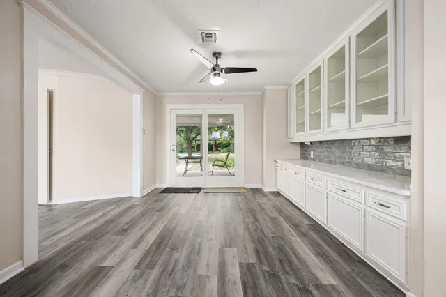 a view of a kitchen with wooden floor and a window