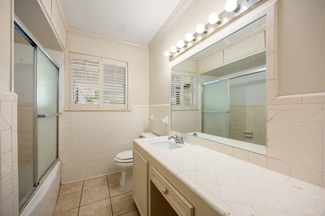 a bathroom with a double vanity sink toilet and shower