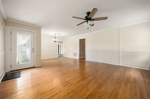 a view of empty room with wooden floor and window