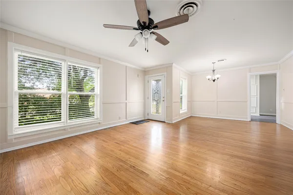 a view of an empty room with a window and wooden floor