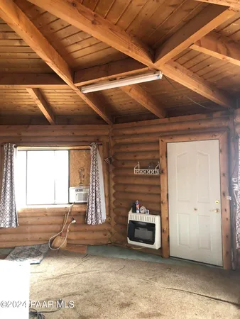 a view of an empty room with wooden floor and a fireplace