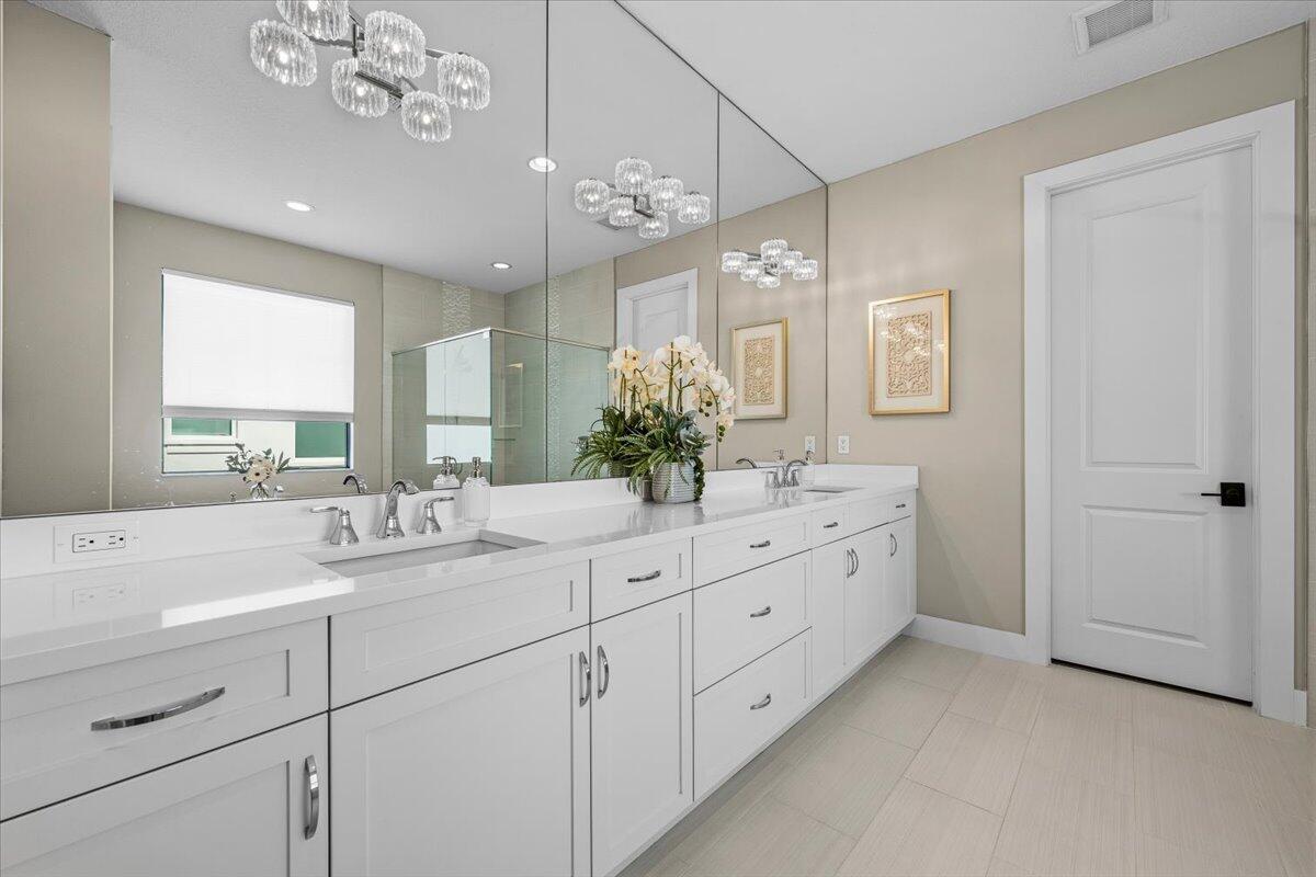 13237 Alton Road Palm Beach Gardens, FL 33418 - Photo 20 of 51 a bathroom with a double vanity sink mirror and chandelier