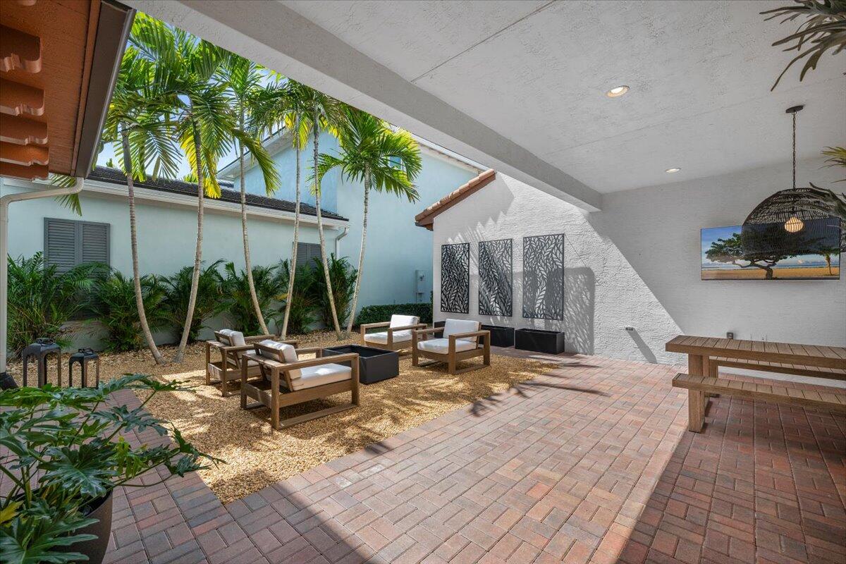 13237 Alton Road Palm Beach Gardens, FL 33418 - Photo 32 of 51 a view of a patio with table and chairs potted plants and large tree