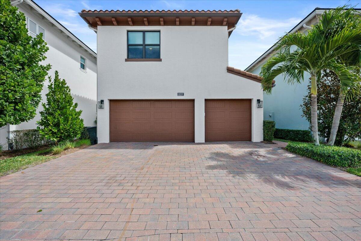 13237 Alton Road Palm Beach Gardens, FL 33418 - Photo 35 of 51 a front view of a house with a yard and a garage