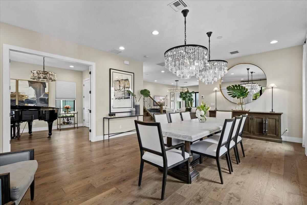 13237 Alton Road Palm Beach Gardens, FL 33418 - Photo 7 of 51 a view of a dining room and livingroom with furniture wooden floor a chandelier