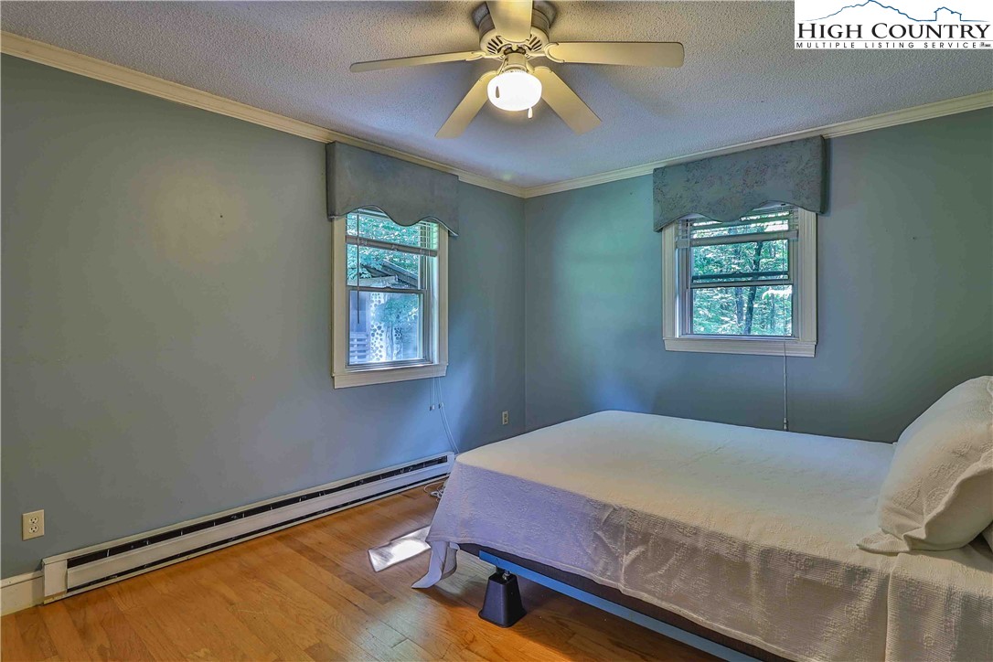 5033 Junaluska Road Boone, NC 28607 - Photo 11 of 34 a bedroom with a bed and a chandelier