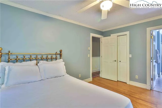 a bedroom with a large bed and a chandelier