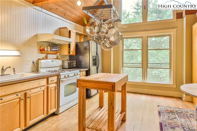 a kitchen that has a stove and a table in it