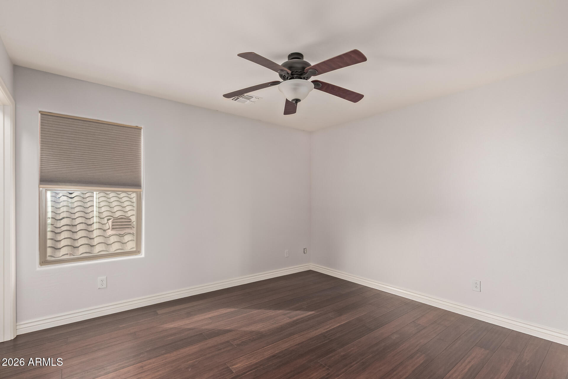 41106 West Coltin Way Maricopa, AZ 85138 - Photo 29 of 51 an empty room with wooden floor ceiling fan and windows