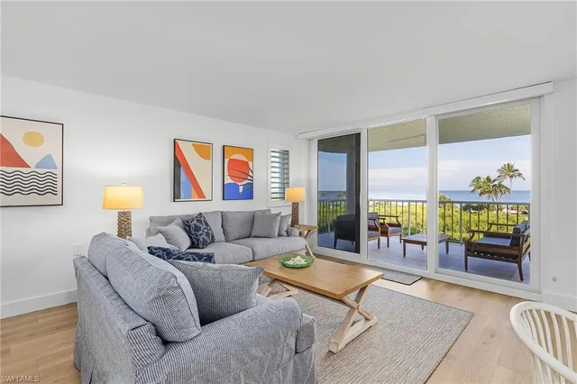 a living room with furniture and a floor to ceiling window