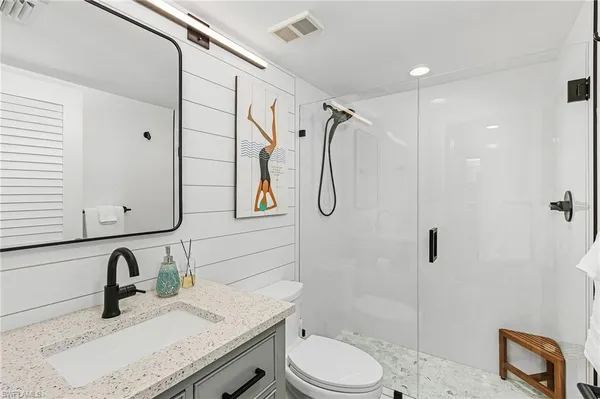 a bathroom with a granite countertop sink toilet and shower
