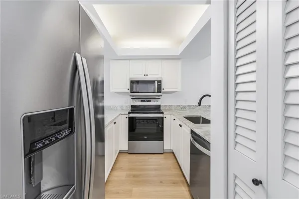 a kitchen with stainless steel appliances granite countertop a refrigerator and a stove