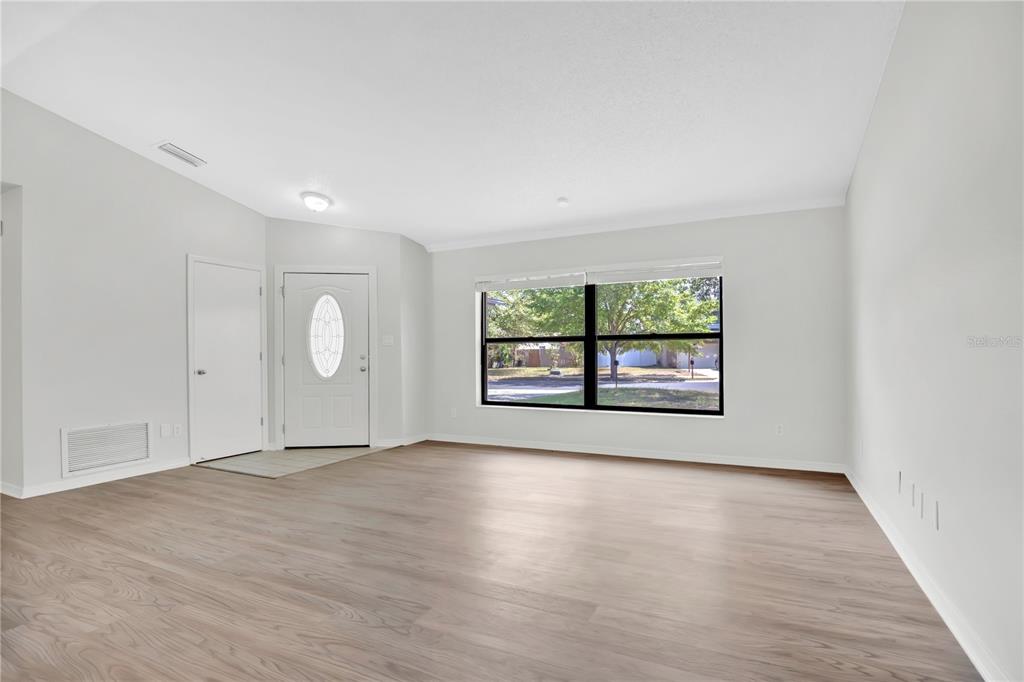 1050 Dishman Loop Oviedo, FL 32765 - Photo 5 of 32 an empty room with wooden floor and windows