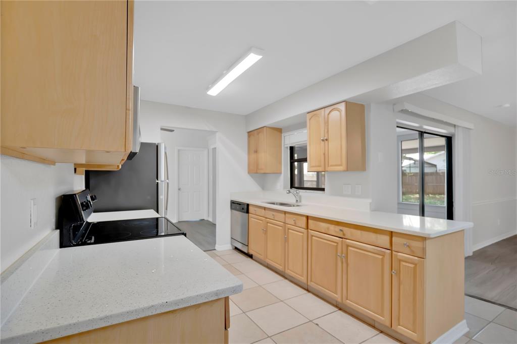 1050 Dishman Loop Oviedo, FL 32765 - Photo 9 of 32 a large kitchen with kitchen island white cabinets and stainless steel appliances