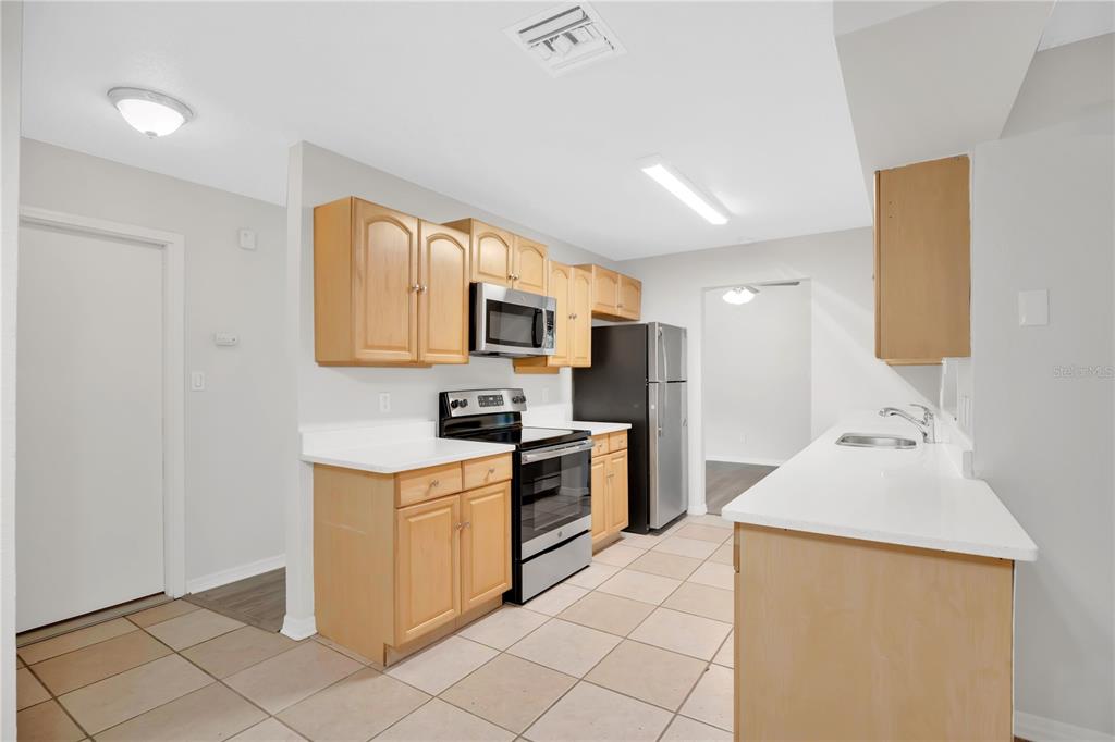 1050 Dishman Loop Oviedo, FL 32765 - Photo 10 of 32 a kitchen with stainless steel appliances a stove refrigerator sink and microwave