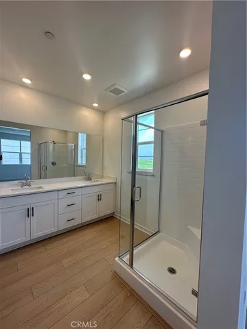 a bathroom with a double vanity sink mirror and shower