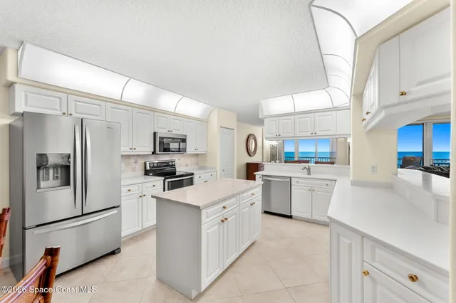 a kitchen with white cabinets and white appliances