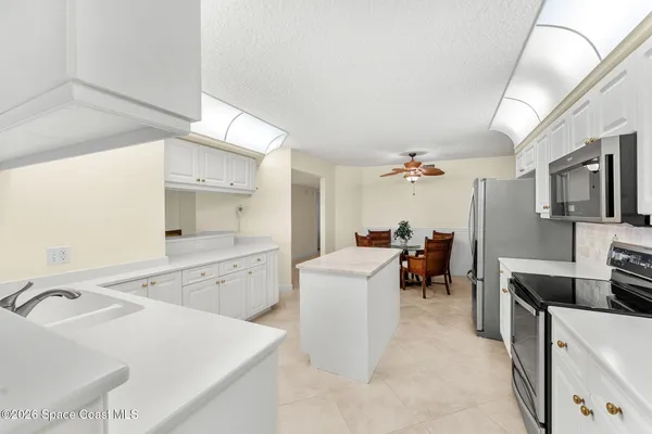 a large white kitchen with a large window