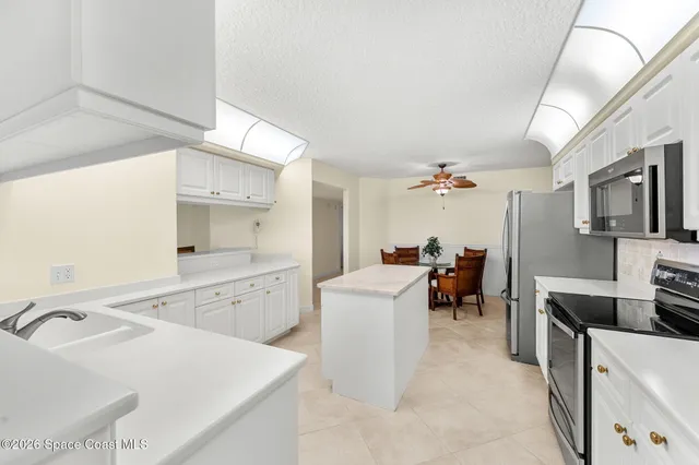 a large white kitchen with a large window